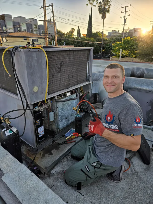 Epic Star lead technician in company uniform servicing an HVAC unit on a Los Angeles rooftop