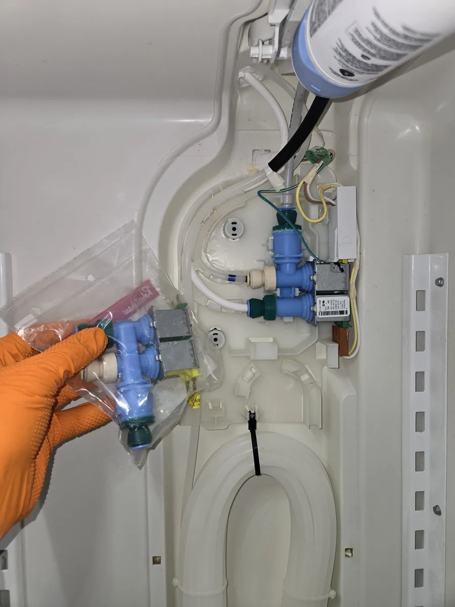 New refrigerator water inlet valve held next to the installed unit by an Epic Star technician in Pacific Palisades, CA
